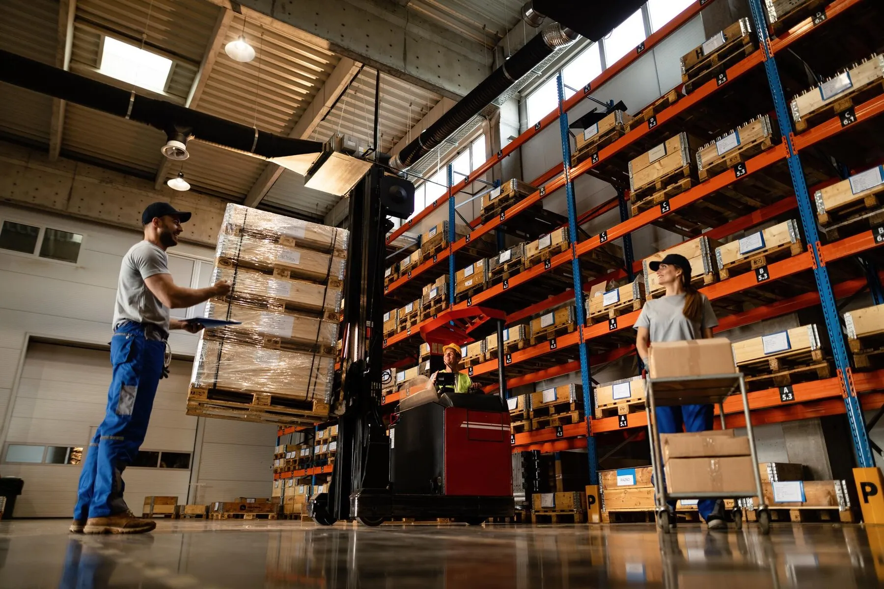 low-angle-view-happy-warehouse-workers-communicating-while-working-with-shipment-industrial-storage-compartment_637285-4208